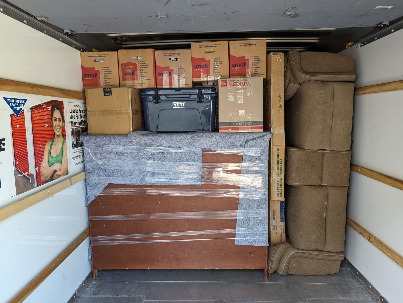 Moving truck loaded with wrapped furniture and boxes stacked securely for transport