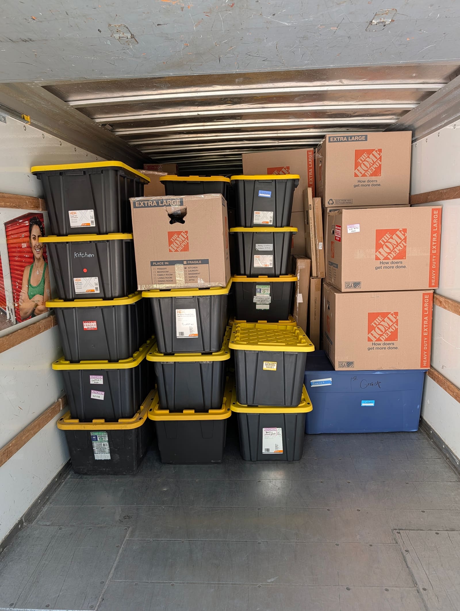 Storage unit organized with labeled totes and moving boxes stacked neatly
